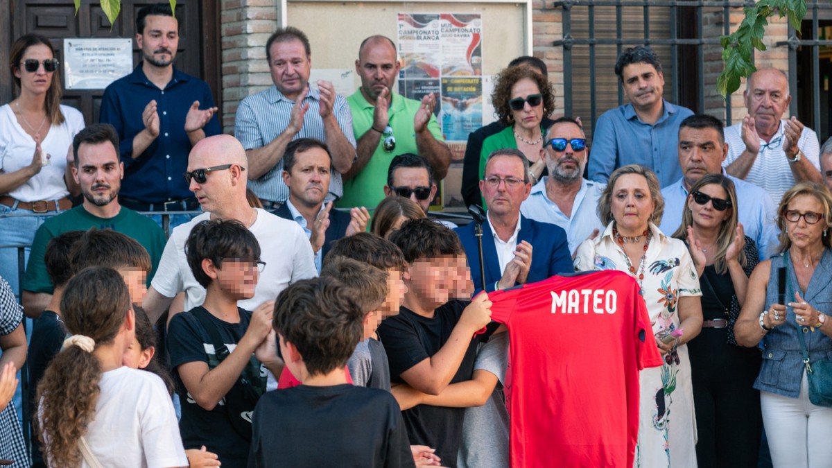 Amigos del niño asesinado muestran una camiseta con su nombre, durante el minuto de silencio por el asesinato de un menor, en la puerta del Ayuntamiento de Mocejón, a 18 de agosto de 2024, en Mocejón, Toledo, Castilla-La Mancha (España). El Ayuntamiento de Mocejón ha decretado tres días de luto oficial por el asesinato en la mañana de hoy de un menor de 11 años, que se encontraba jugando al fútbol junto a otros niños de la localidad en el campo de fútbol municipal 'Ángel Tardío' cuando fue agredido con un objeto punzante. 18 AGOSTO 2024;ASESINATO;MENOR;NIÑO APUÑALADO;TOLEDO;CRIMEN;MINUTO DE SILENCIO;GUARDIA CIVIL;PIXELADA Juan Moreno / Europa Press 18/8/2024