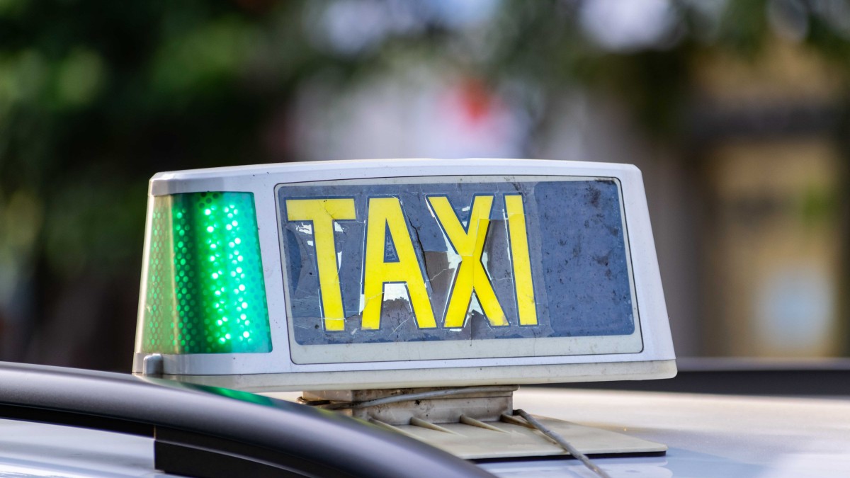 A closeup shot of the broken Taxi sign attached to the roof of a car